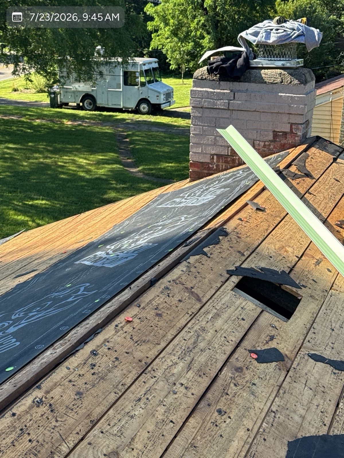 Roof tear-off revealing plank decking with repaired sections