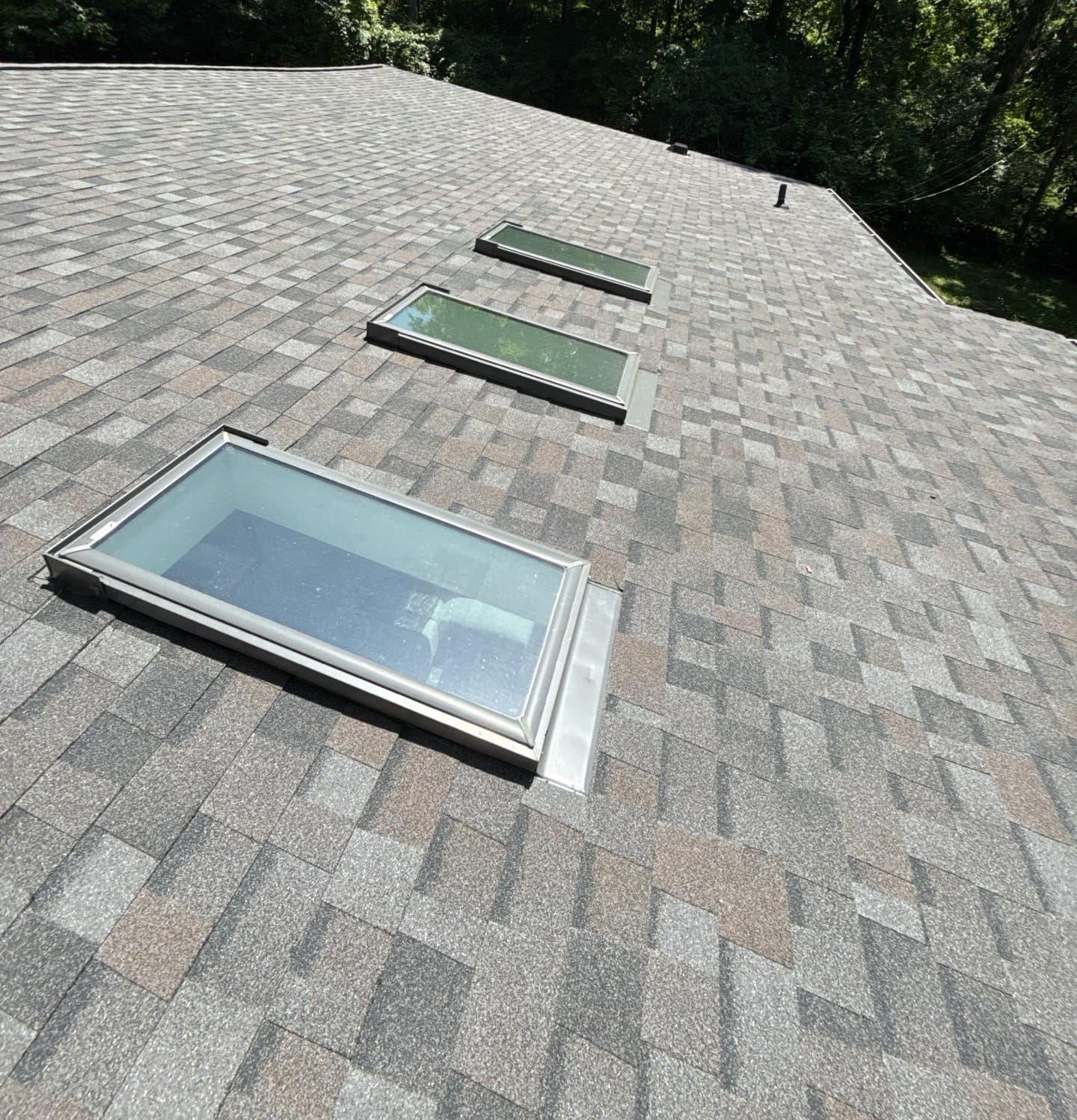 Finished architectural shingle roof with reflashed skylights